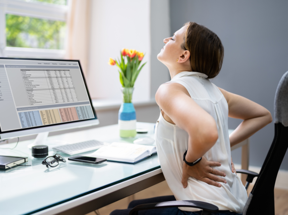 Woman sitting at a desk with lower back pain from bad posture